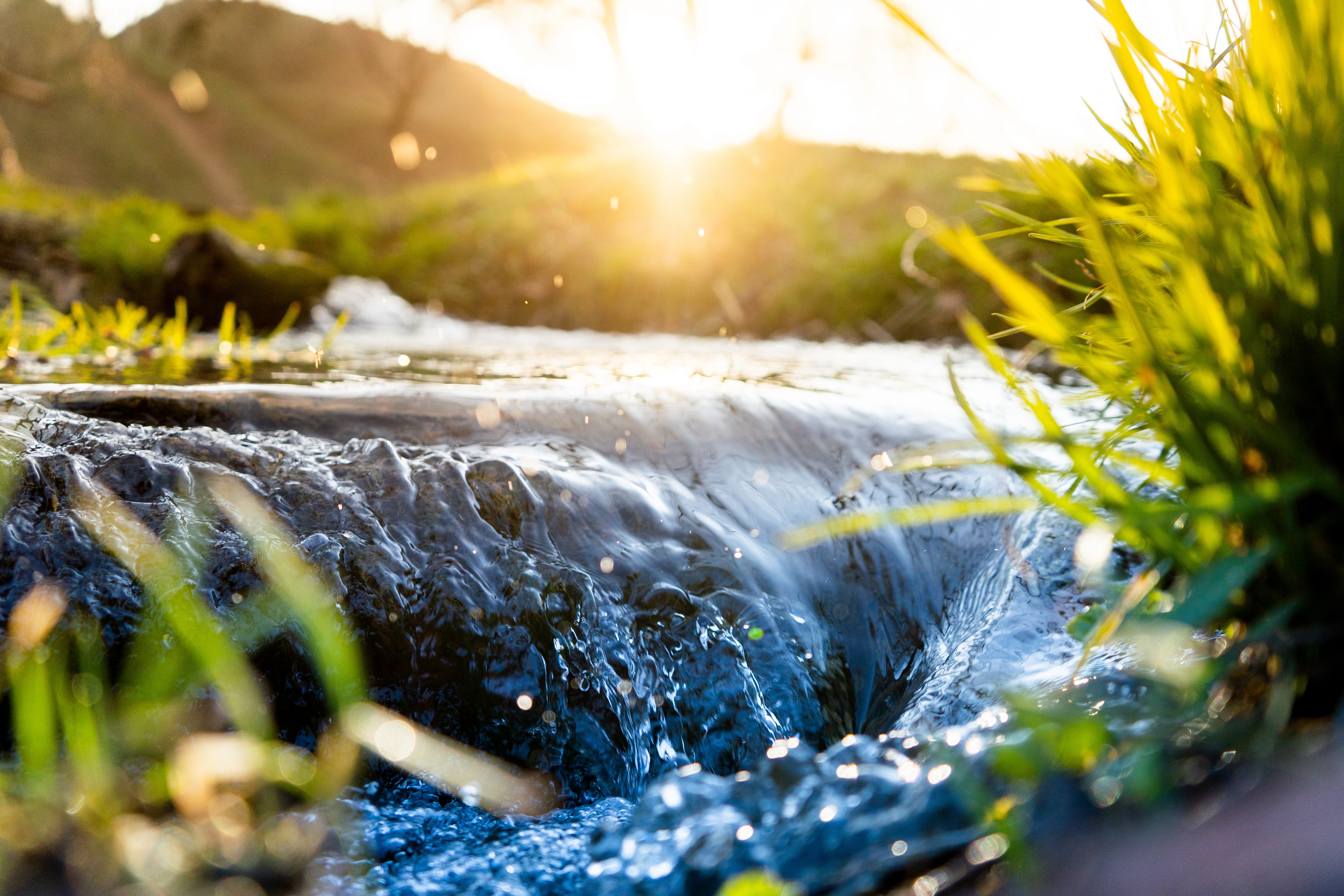 water flowing through a stream sunrise light brook