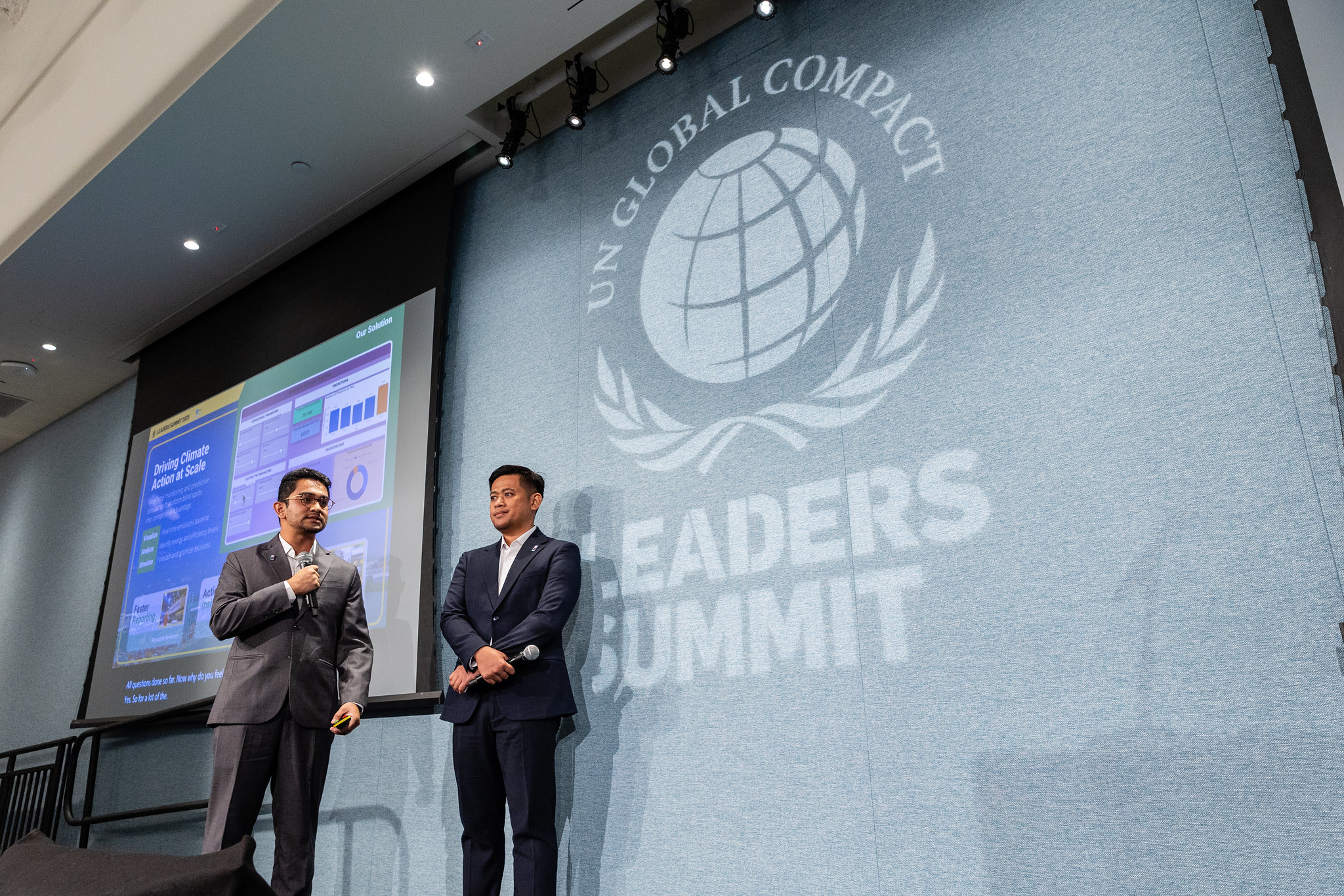 Two people standing in front of a Leaders Summit backdrop at UNGA 2025