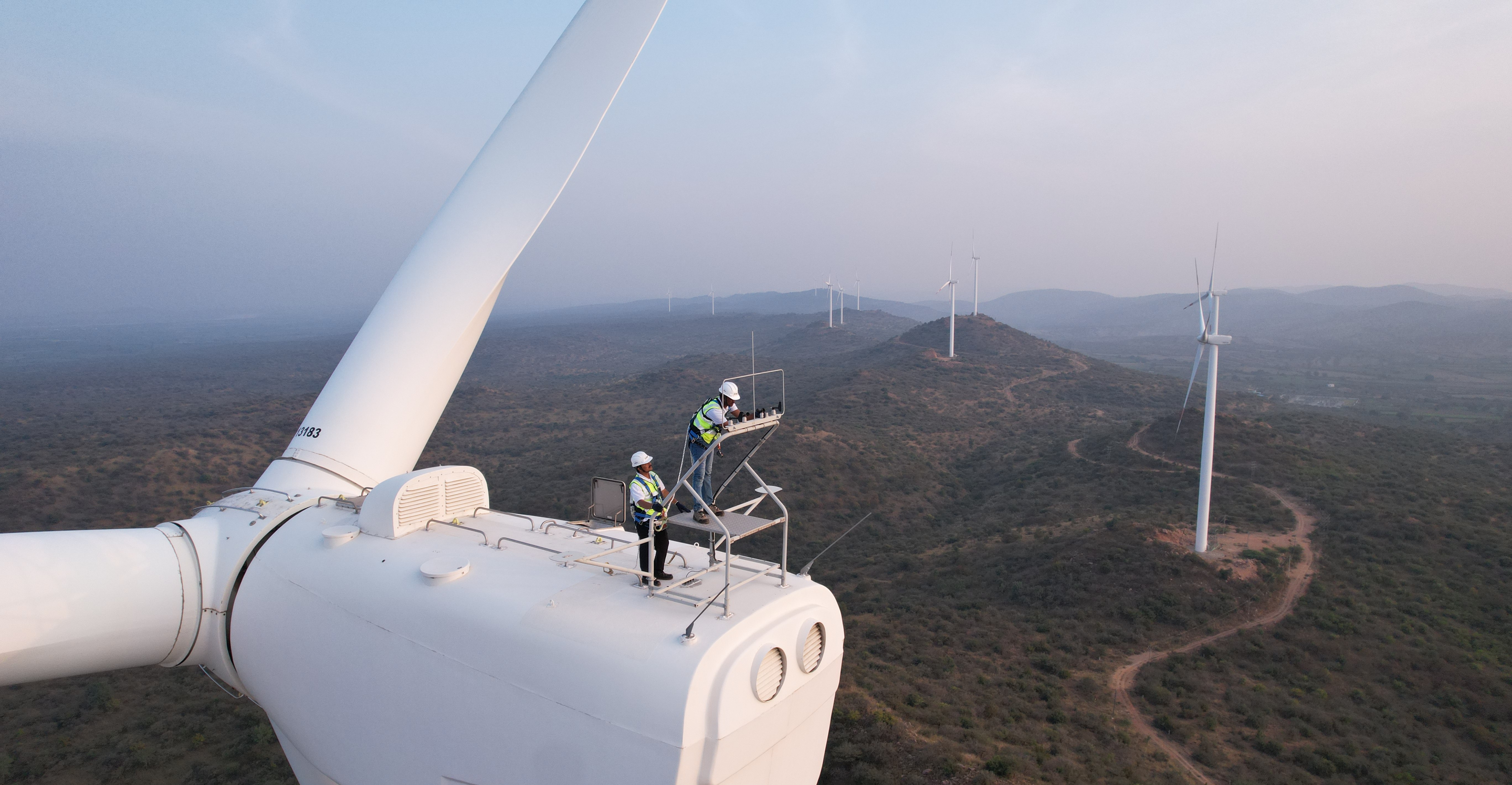 Two men working on a wind tower