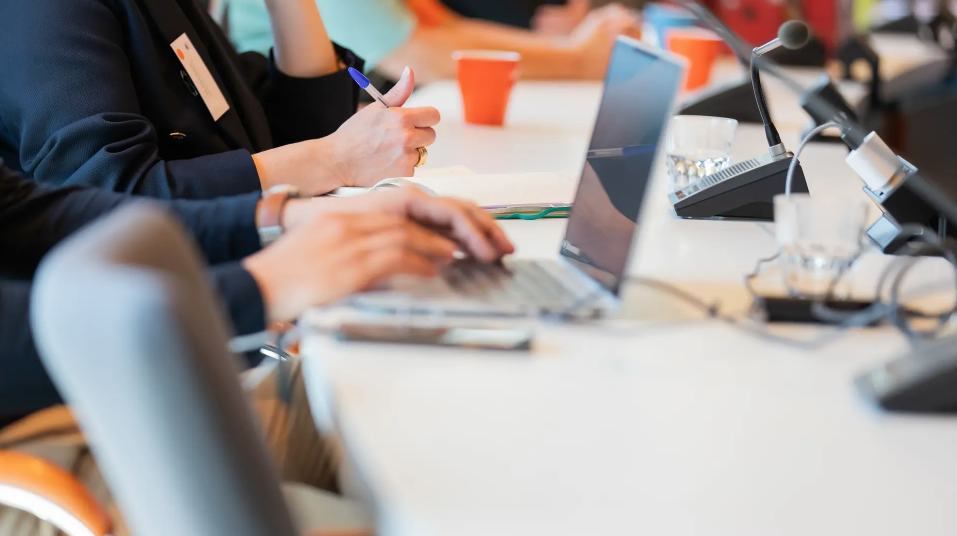 People in meeting taking notes in computer